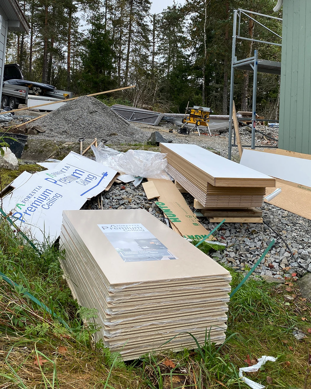 Takplater og veggplater har blitt levert og ligger klare utenfor hytta.