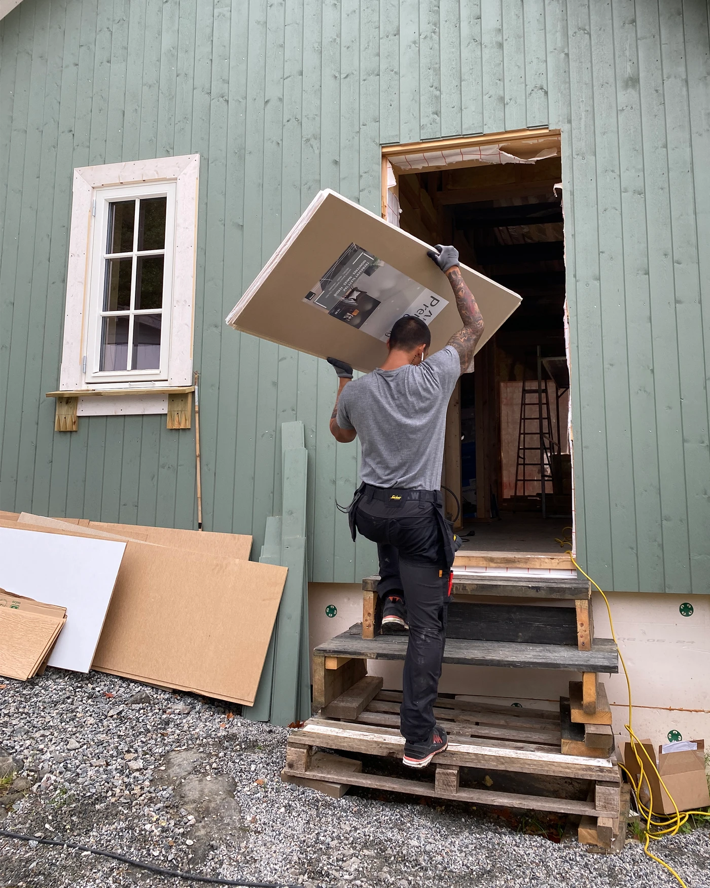 Takplatene Forestia Premium Ceiling bæres inn av håndverkeren.